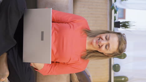 Vertikales-Video,-In-Dem-Die-Frau-Zufrieden-Mit-Dem,-Was-Sie-Auf-Dem-Laptop-Sieht,-Nickt.